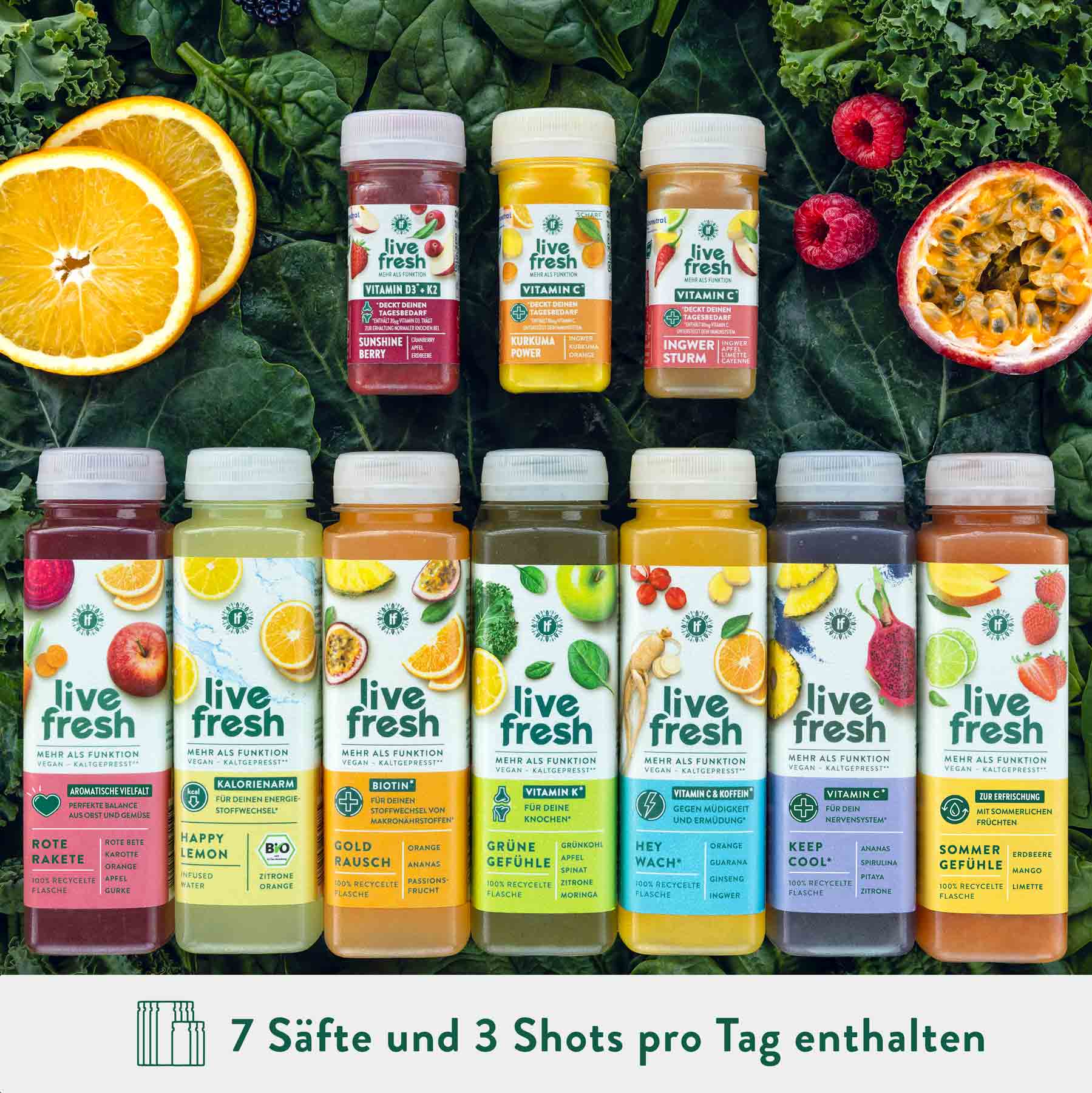Saftkur von LiveFresh mit verschiedenen kaltgepressten Säften und Ingwer Shots. Im Hintergrund Obst und Gemüse