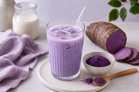 Ube Latte mit lila Ube-Pulver und aufgeschnittener violetter Ube-Yamswurzel