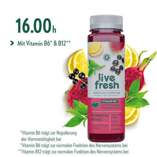 Live fresh Kombucha Ritual Flasche mit Johannisbeere Pitaya Kombucha und Zitrone vor Zitrone Pitaya Johannisbeeren und grünen Blättern als Teil einer Saftkur Tagesroutine. Der Text lautet 