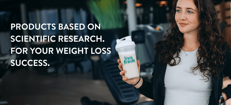 A brunette woman with a white tshirt and a black sweatshirt is holding a shaker with the logo of LiveFresh. On the left side of the picture it says 