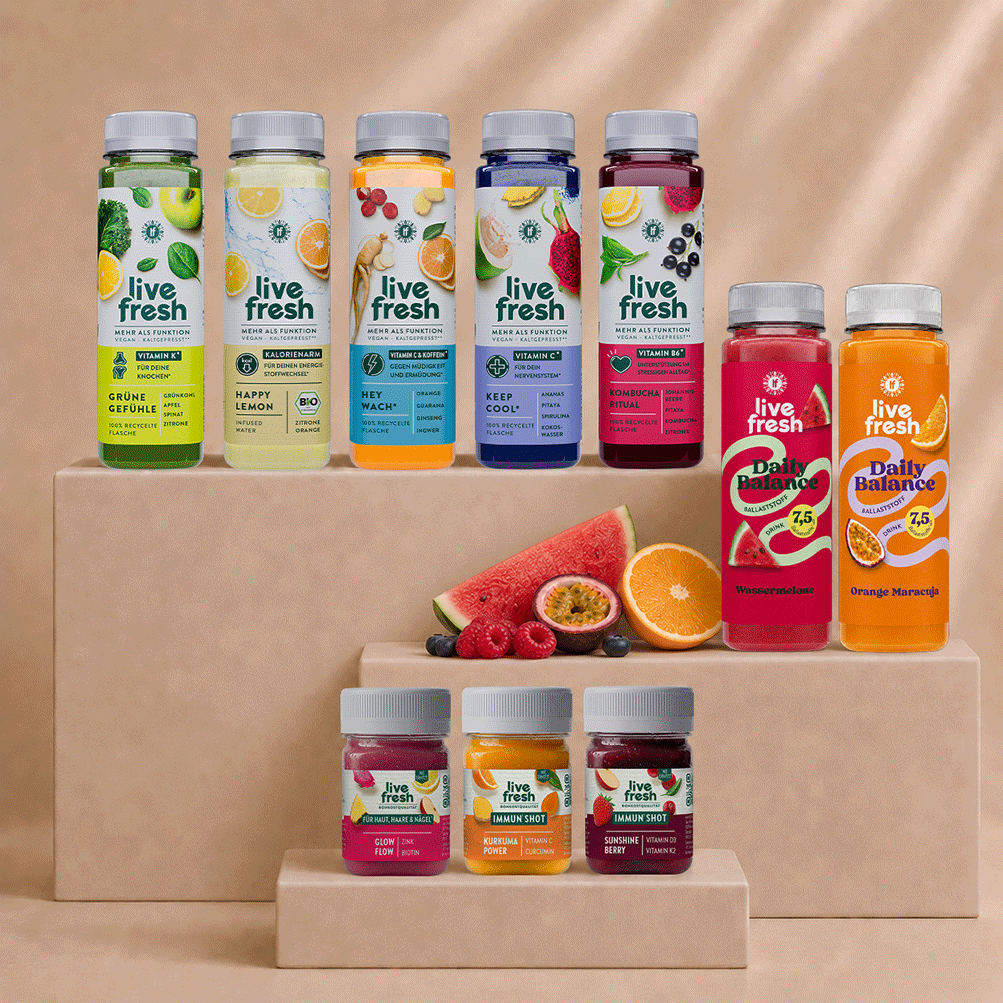 Live Fresh Balance Kur mit verschiedenen Säften und Shots auf beigen Podesten. Zu sehen sind unter anderem Grüne Gefühle, Happy Lemon, Hey Wach, Keep Cool, Kombucha Ritual sowie Daily Balance Drinks und Immun Shots mit frischem Obst.