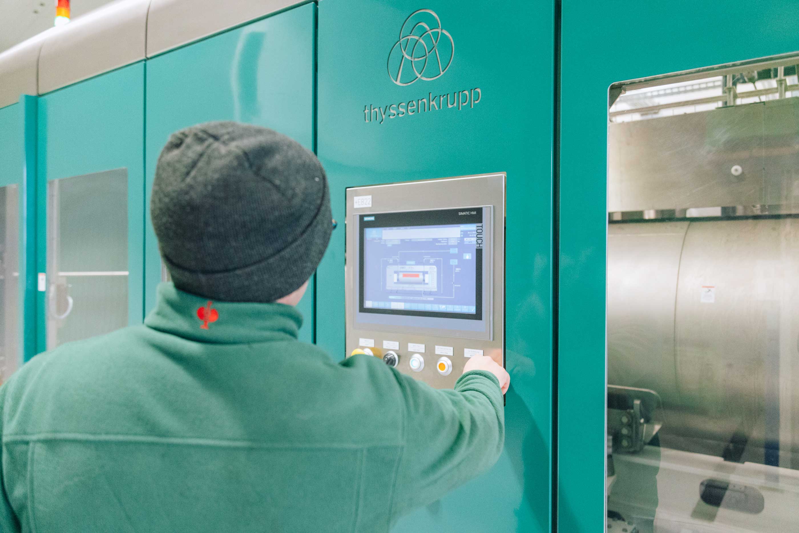 Mitarbeiter steuert HPP-Anlage über ein Touchdisplay für die druckbasierten Saftkonservierung.