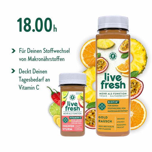 Zwei Flaschen „Live Fresh“-Saft, umgeben von Früchten wie Ananas, Orange und Maracuja. Die große Flasche „Gold Rausch“ enthält Biotin „Für Deinen Stoffwechsel von Makronährstoffen“. Die kleinere Flasche „Ingwer Sturm“ ist eine scharfe Mischung aus Ingwer, Apfel und Cayenne. Beide Säfte sind vegan, kaltgepresst und decken den Tagesbedarf an Vitamin C. Links steht die empfohlene Trinkzeit „18.00h“.