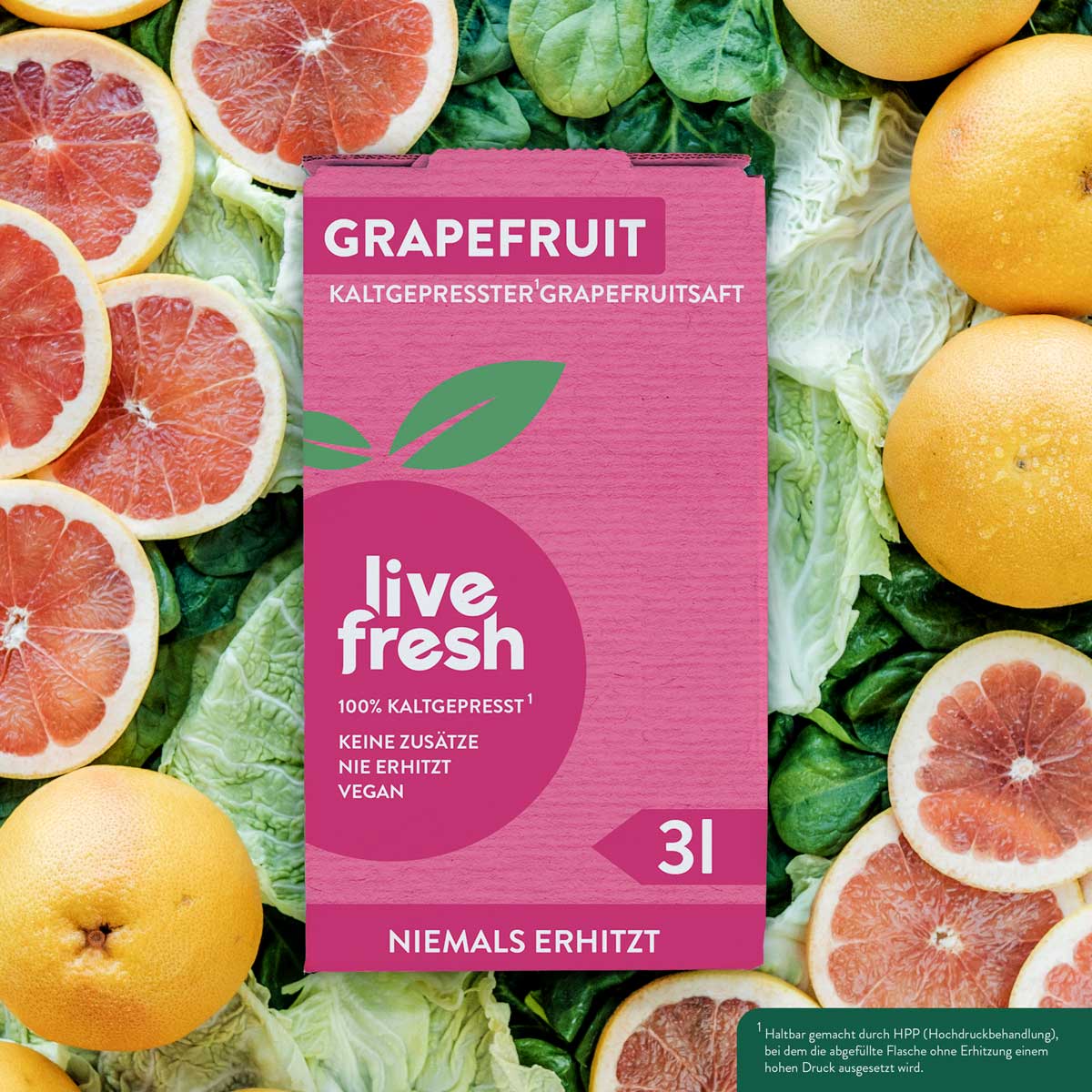 Eine „Live Fresh“ Verpackung für kaltgepressten Grapefruitsaft mit 3 Litern Inhalt. Auf der Verpackung steht „100% Kaltgepresst, Keine Zusätze, Nie Erhitzt, Vegan“ sowie „Niemals Erhitzt“. Im Hintergrund sind frische Grapefruits und geschnittene Grapefruitscheiben auf grünem Blattgemüse zu sehen. Die Verpackung betont die Frische und Qualität des Safts, der durch das Hochdruckverfahren (HPP) haltbar gemacht wird, ohne erhitzt zu werden.