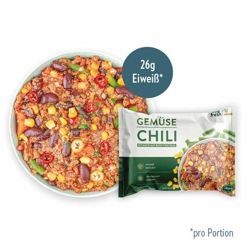 Packung „Live Fresh Gemüse Chili“, ein veganes Gericht mit Soja-Hack und Gemüse wie Bohnen, Mais und Chili. Die Mahlzeit enthält 26 Gramm Eiweiß pro Portion und wird als tiefgekühlt lagerbar beworben. Daneben ist das fertige Gericht in einer Schale zu sehen, bunt angerichtet mit frischen Zutaten.