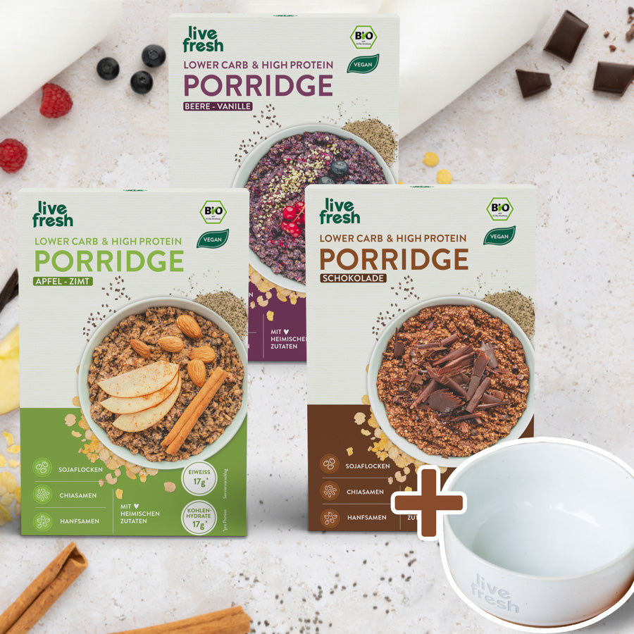 „Live Fresh“ Porridge in verschiedenen Geschmacksrichtungen: Apfel-Zimt, Beere-Vanille und Schokolade. Jede Packung betont, dass das Porridge „Lower Carb & High Protein“ ist, vegan und mit heimischen Zutaten hergestellt wird. Die Hauptzutaten wie Sojaflocken, Chiasamen und Hanfsamen werden hervorgehoben, und jedes Porridge enthält 17g Eiweiß und Kohlenhydrate. Um die Packungen herum sind passende Lebensmittel wie Beeren, Schokolade und Zimtstangen dekorativ arrangiert.