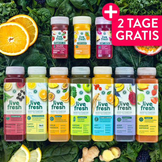 Sortiment aus mehreren LiveFresh Säften und funktionalen Shots für eine Saftkur, arrangiert auf frischem Blattgemüse mit Zitrusfrüchten, Ingwer und weiteren Zutaten. Die unterschiedlichen Farben der Flaschen verdeutlichen die Vielfalt der enthaltenen Frucht und Gemüsesäfte. Werbegrafik mit dem Text "2 TAGE GRATIS".